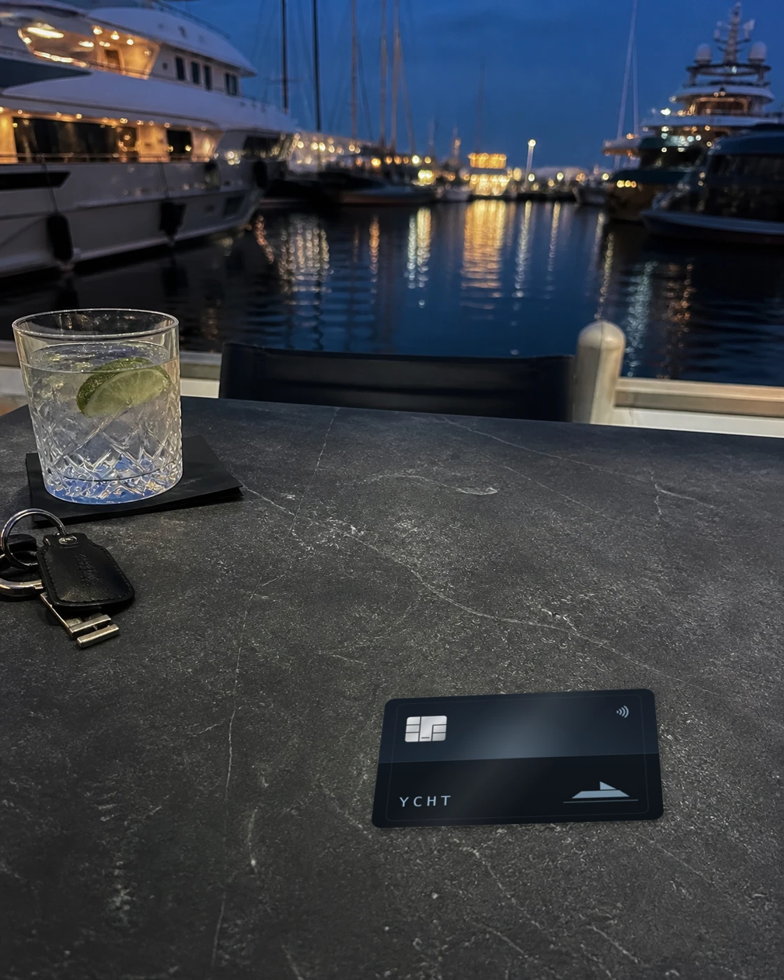 The YCHT card on a marina table at blue hour.